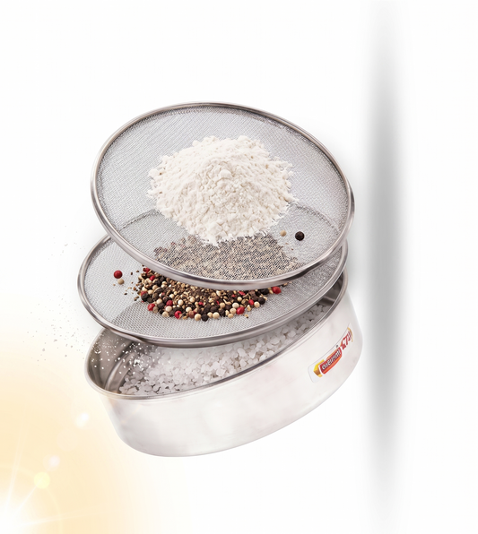 Three overlapping stainless steel sifter sieves with mesh screens, shown floating on a white background. The sieves contain white flour, coarse salt, and a mixed peppercorn pile.