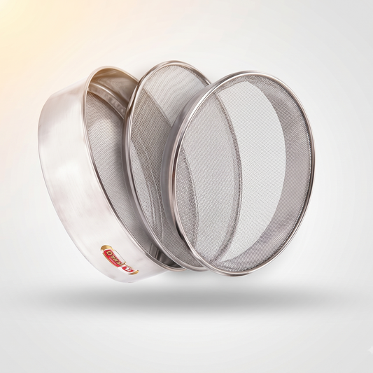 Three round metal sieves of different mesh sizes, arranged in a fan-like stack, on a light gray background with a soft shadow and a warm light flare in the top-left corner.
